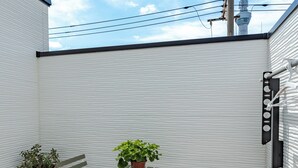 A small outdoor space with a table and two chairs, a potted plant, and a view of a tower in the background. - Located 650 meters from Tokyo Skytree, with direct access from Narita and Haneda Airports. A two-story single-family home that accommodates up to 7 guests. A 4-minute walk from the nearest station. (墨田区)