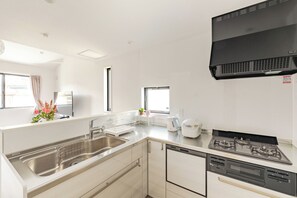 A modern kitchen with a stainless steel sink, a built-in dishwasher, a stove, and a window with a view. - Located 650 meters from Tokyo Skytree, with direct access from Narita and Haneda Airports. A two-story single-family home that accommodates up to 7 guests. A 4-minute walk from the nearest station. (墨田区)