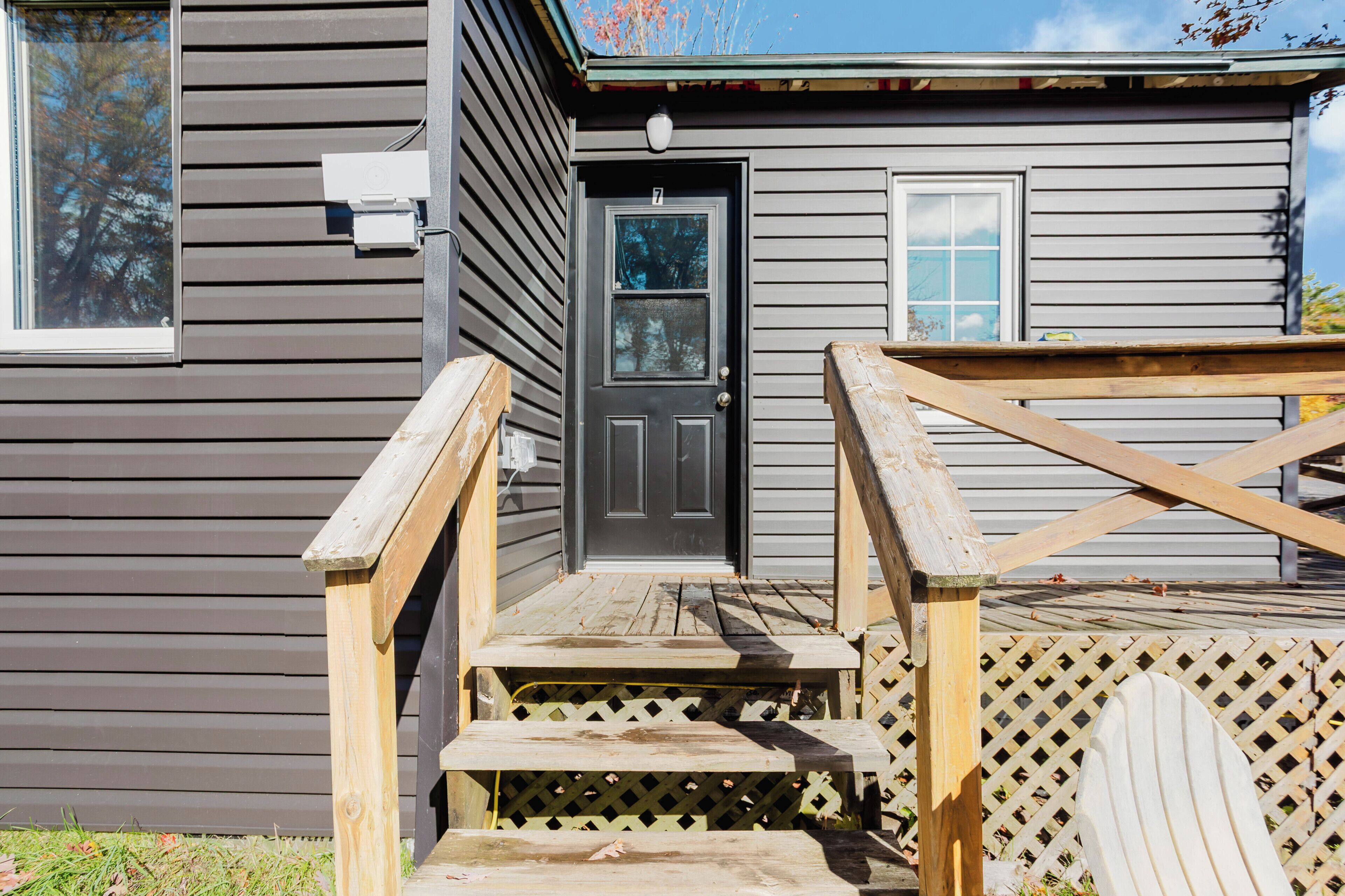 A house with a front door, a small porch, and a wooden fence.