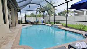 A covered outdoor swimming pool with lounge chairs and a basketball hoop. - Pool Waterfall | 4BR | S. Exposure | Dogs OK (Cape Coral)