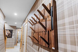 Ein Korridor mit einer Wand aus Holzleisten und einem Schachbrettmuster auf dem Boden.