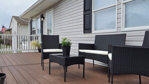 A covered outdoor deck with a seating area, including a table and two chairs. - Lovely 2-bedroom house with AC near charming Delaware Bay (Lower Township)