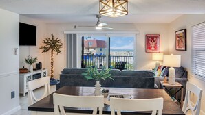 Un salon moderne comprenant une table à manger, des canapés, un téléviseur et un balcon avec vue.