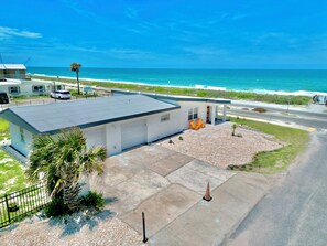 A modern building with a flat roof, a covered patio area, and a view of the ocean. - Direct Oceanfront House – Newly Renovated with Stunning Views-Sleeps 5-2bed2bath (Flagler Beach)