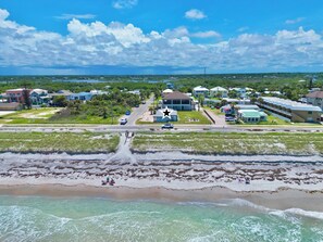 An aerial view of a coastal area with residential buildings, a road, and a beach. - Direct Oceanfront House – Newly Renovated with Stunning Views-Sleeps 5-2bed2bath (Flagler Beach)