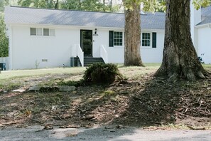 A white single-story house with a front porch, a mailbox, and a large tree in front. - Spacious 4-bedroom house in delightful Richmond (Richmond)