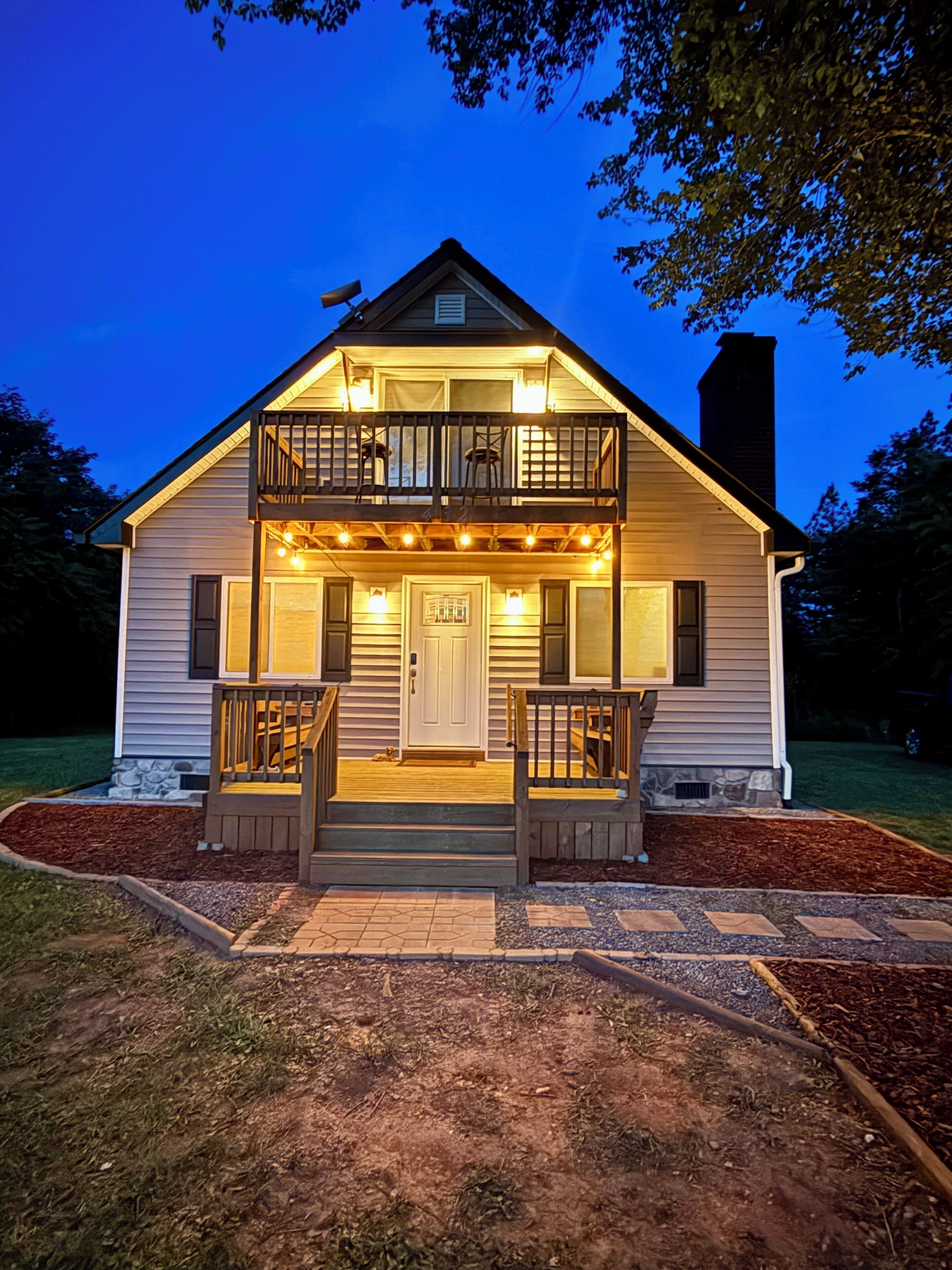 A two-story house with a balcony, a front door, and a small porch area.