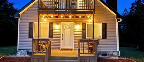 A two-story house with a balcony, a front door, and a small porch area.