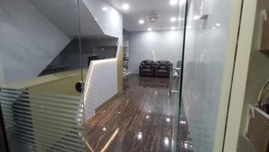 Ein modernes Interieur mit Glastrennwand, Empfangsbereich und Sitzgelegenheit.
