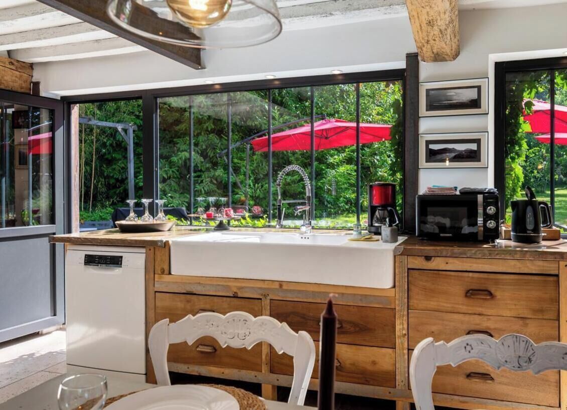Una cocina moderna con un ventanal grande, armarios de madera y lavavajillas integrado.