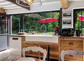 Una cocina moderna con un ventanal grande, armarios de madera y lavavajillas integrado.