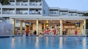 Um hotel com piscina, área de estar ao ar livre e um bar.