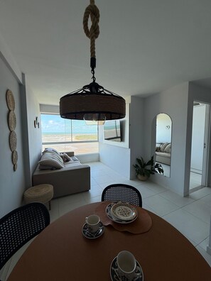 Uma área de refeições com uma mesa redonda, cadeiras e um lustre.