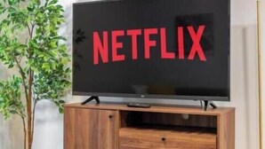 Un televisor con el logotipo de Netflix en la pantalla, sobre un soporte de madera.