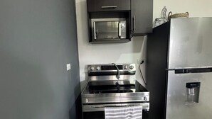 Cocina compacta con microondas, horno y refrigerador integrados.