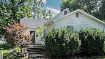 A single-story house with a front door, steps leading up to the entrance, and a small porch.