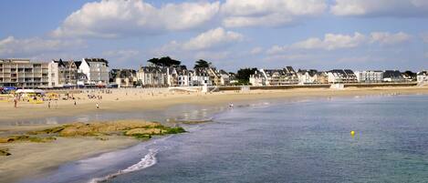 A coastal beach with buildings in the background.