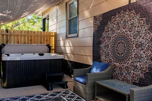 A hot tub, wicker furniture, and a decorative wall. - The Walnut Retreat~Whole house! Hot Tub~Library~ (Des Moines)