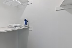 A clean, white bathroom with a towel stack and an iron on a shelf. - The Grand Estate . Private Pool . Sleeps 10 . Events Welcome (Grandview)