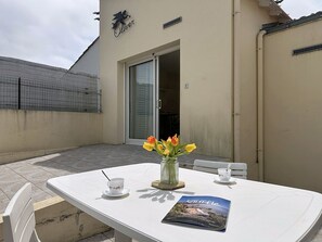 Ein weißer Tisch mit einer Zeitschrift, einer Tasse und einer Blumenvase.