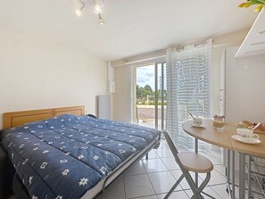 Een slaapkamer met een bed, een tafel met ontbijtartikelen en uitzicht door een glazen deur.