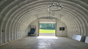 Ett stort, välvt, inomhusutrymme med en basketkorg, en darttavla och en kristallkrona.