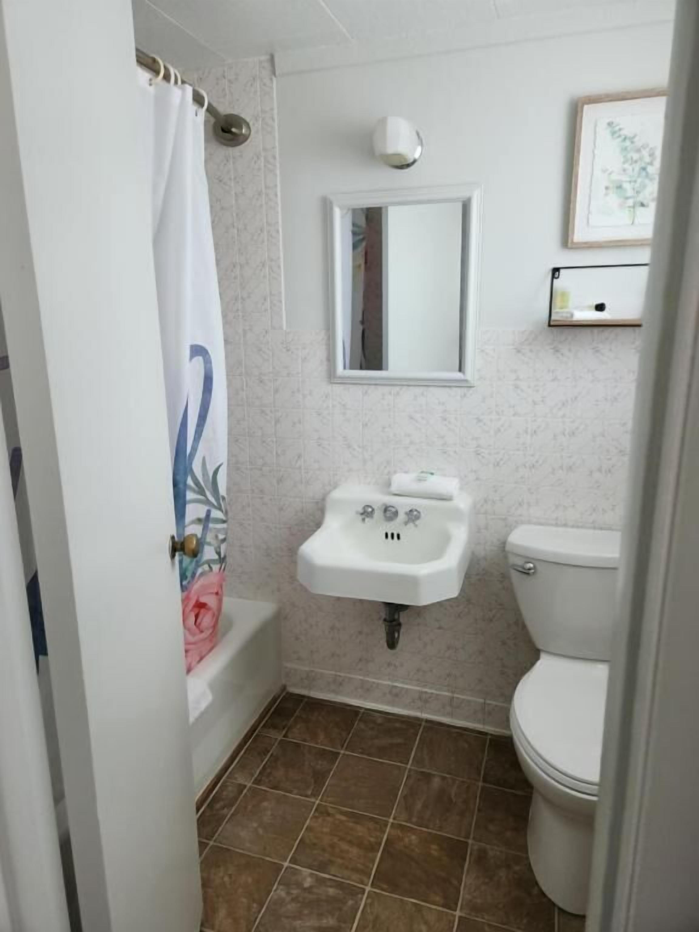 A bathroom with a bathtub, a sink, and a toilet.