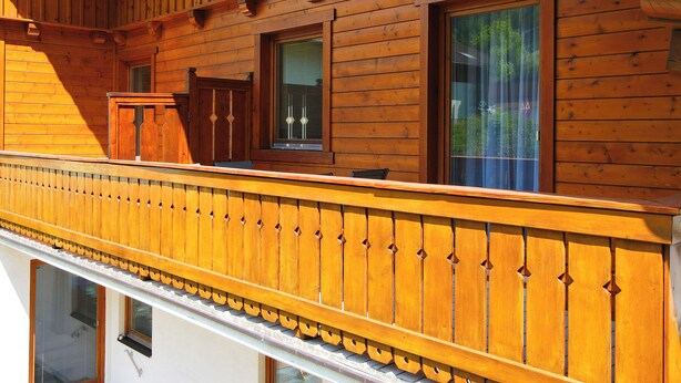 Un bâtiment en bois doté d’un balcon, de fenêtres et d’une porte.
