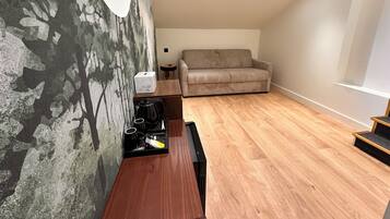 Una sala de estar moderna con un sofá, una mesa de centro y una pared con un mural de un árbol.