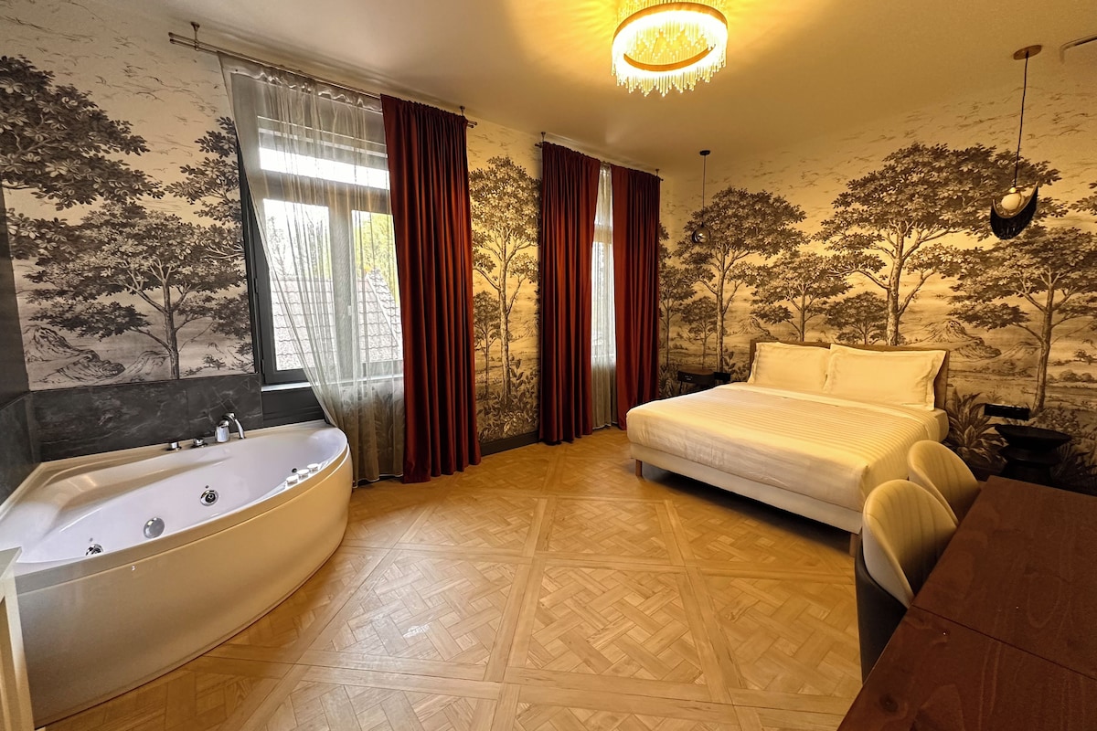 Ein Schlafzimmer mit einem großen Bett, einer Badewanne und einem Esstisch.