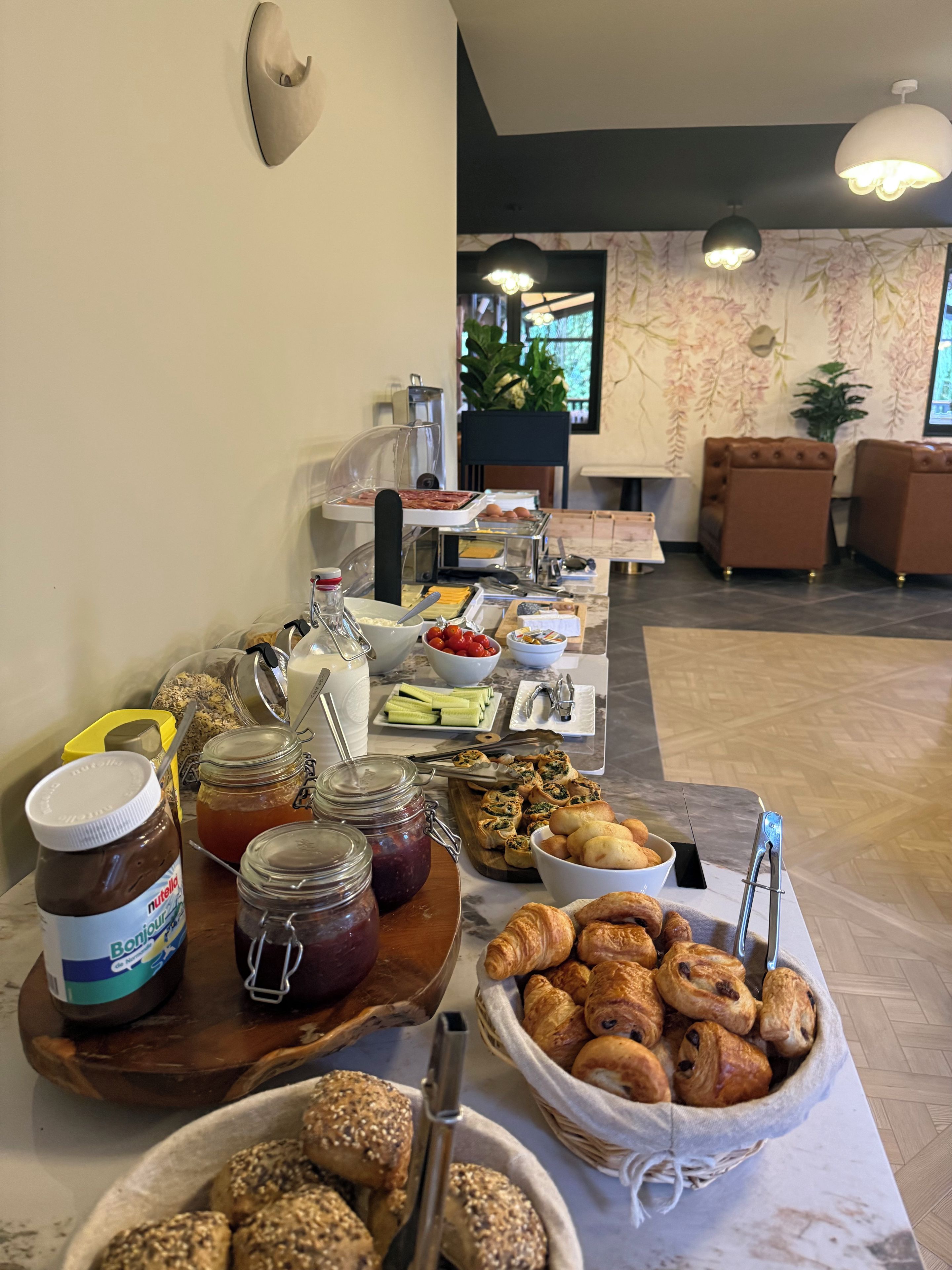 Un buffet proposant une variété de plats, notamment des pâtisseries, des tartinades et des condiments.