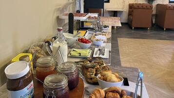 Un buffet proposant une variété de plats, notamment des pâtisseries, des tartinades et des condiments.