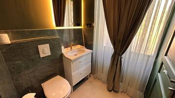 Ein Badezimmer mit Toilette, Waschbecken und Spiegel.