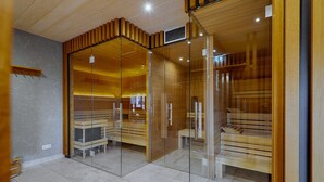 Een sauna met houten banken en glazen scheidingswanden.