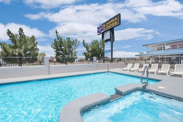 Unwind poolside under bright skies with lounge chairs nearby.