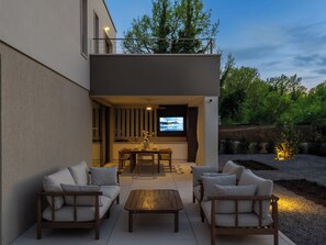 A modern outdoor living area with a dining table, chairs, and a sofa. - Vacation home Nara by Interhome (Labin)