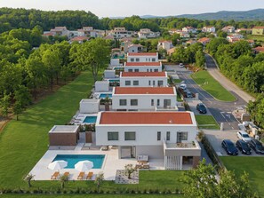 A modern residential area with houses, a swimming pool, and a road. - Vacation home Nara by Interhome (Labin)