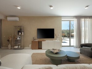 Een moderne woonkamer met een flatscreen televisie, een boekenkast, een salontafel en een bank.