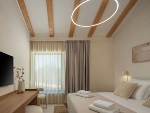A hotel room with a bed, a desk, a chair, a TV, and a window with curtains. - Vacation home Orla by Interhome (Labin)
