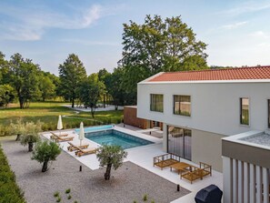 A modern house with a swimming pool, outdoor seating, and a view of a park. - Vacation home Orla by Interhome (Labin)
