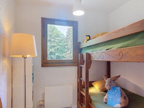 A bunk bed with a view of trees, a lamp, and a stuffed toy. - Les Tétras by Interhome (Saint Gervais)