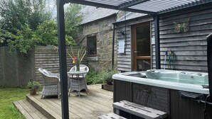 A patio with a hot tub, outdoor furniture, and a pergola. - Country cottage hot tub with gazebo peaceful (Otley)