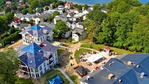 Un quartier résidentiel avec des maisons, un grand immeuble doté d’un toit bleu et une vue sur la mer.