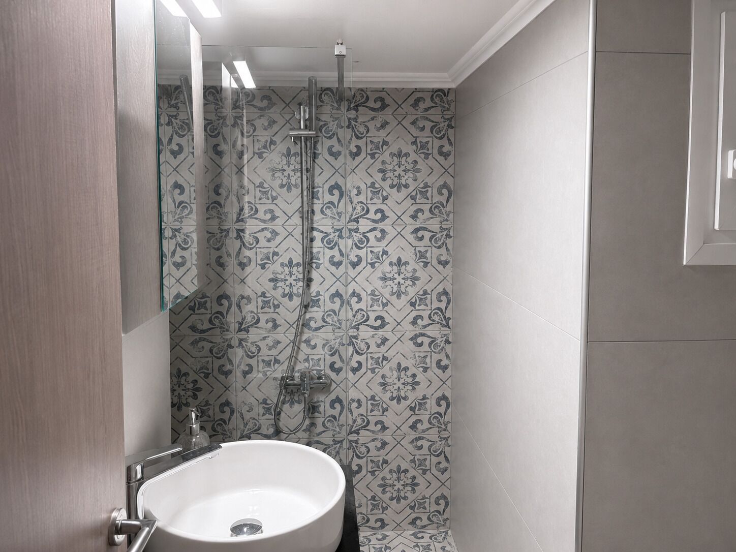 Une salle de bain avec un lavabo, un miroir et une douche.