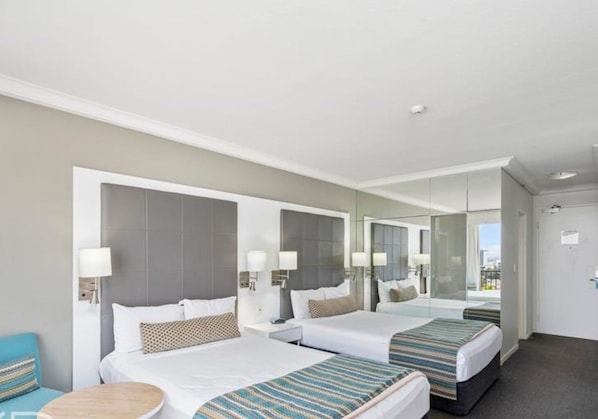 A hotel room with two beds, a small round table, and a mirror. - Mantra on View: Surfers Paradise by Ready Set Stay (Surfers Paradise)