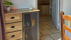 Ein Flur mit einem Holzschrank, einer Topfpflanze und einem Schild mit der Aufschrift 'GOOD VIBES ONLY'.
