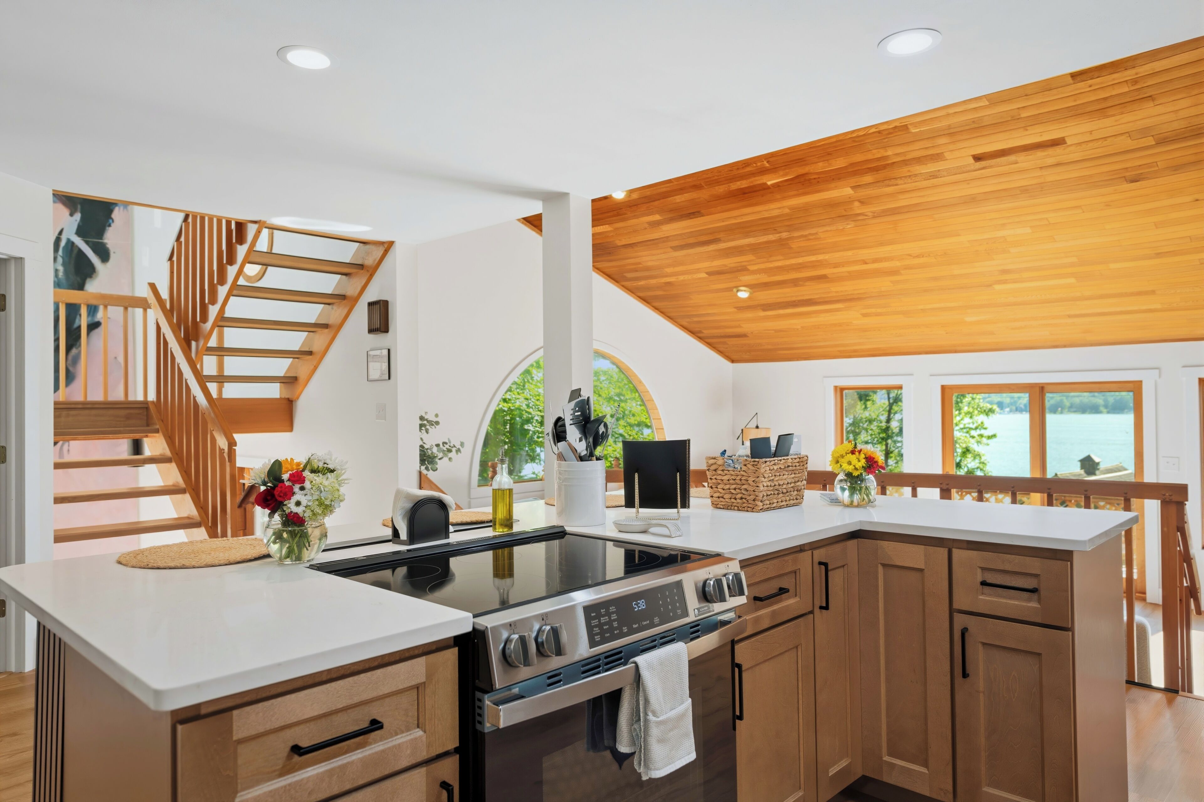 Una cocina moderna con armarios de madera, horno empotrado y campana extractora de acero inoxidable.