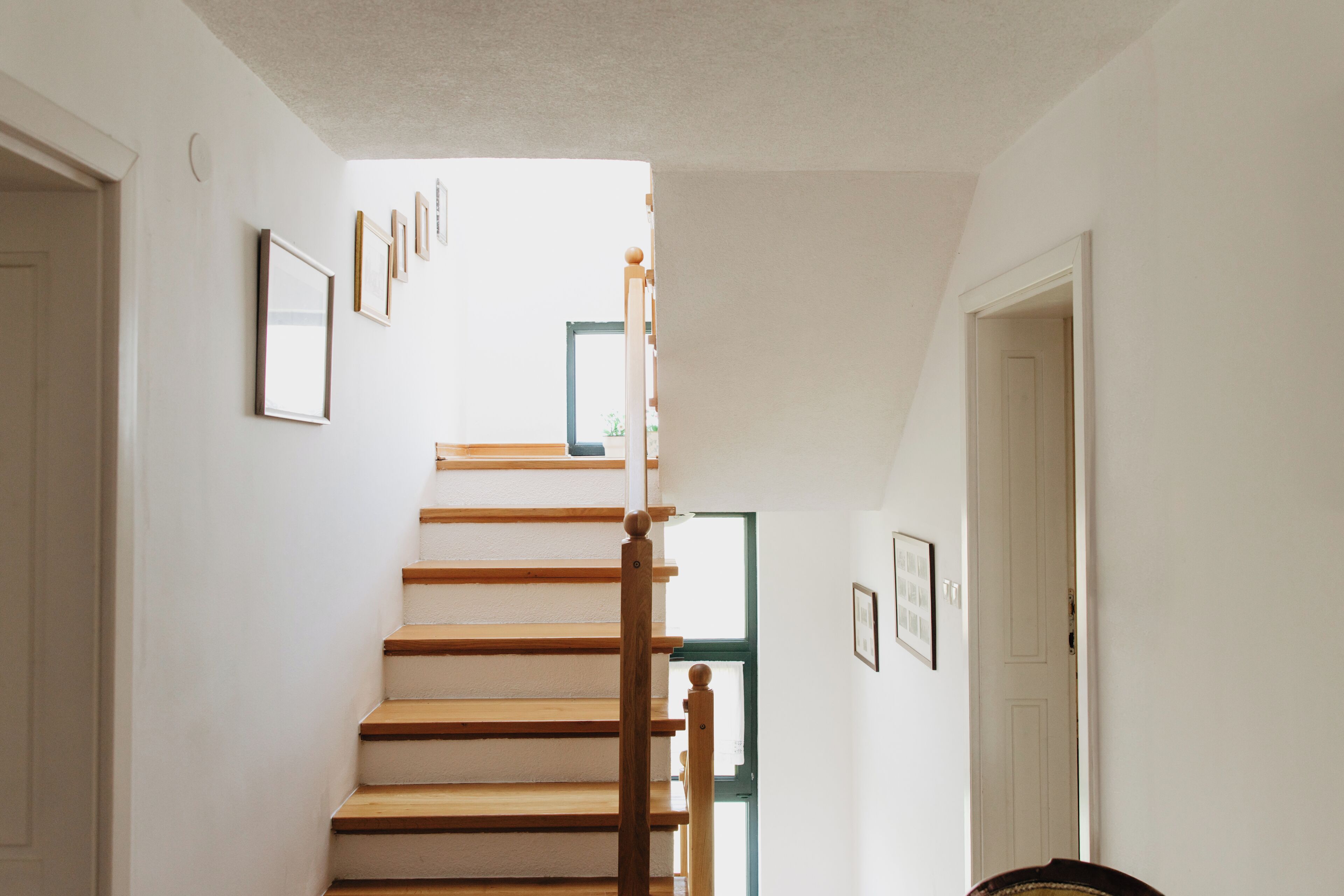 Un escalier avec des marches en bois et une rampe en bois, menant à une porte située en haut.