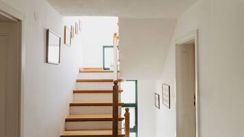 Un escalier avec des marches en bois et une rampe en bois, menant à une porte située en haut.