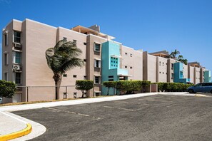 A multi-story hotel with a modern design, featuring balconies and a parking area. - Walk to the Beach! Quiet Resort Retreat in Maunabo (Maunabo)